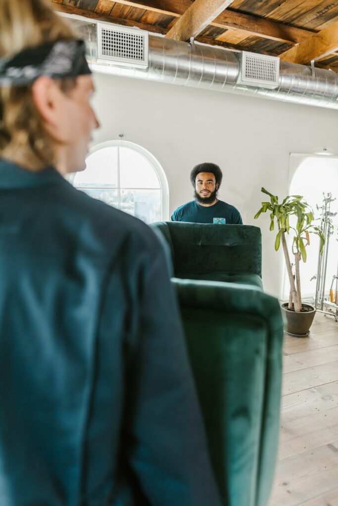 Two Men Moving a Green Couch