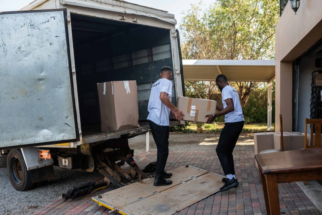 a couple of men loading boxes into a truck