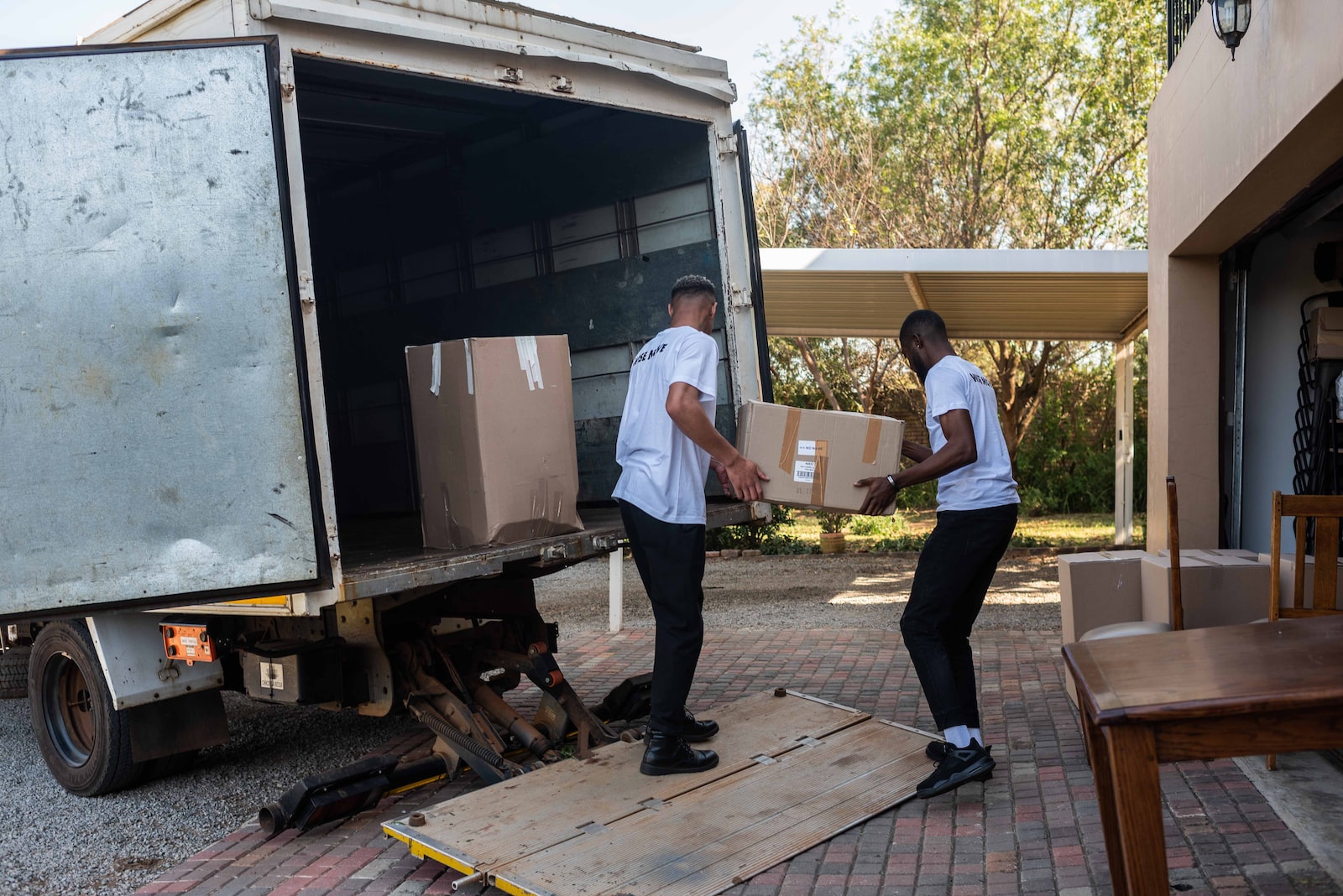 a couple of men loading boxes into a truck